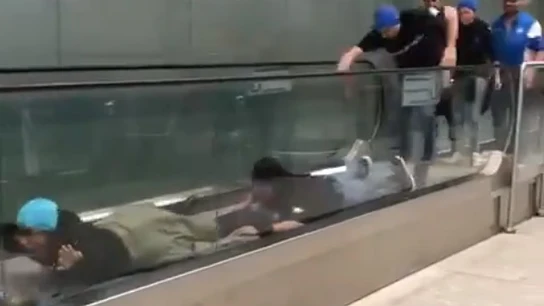 Aficionados del Atalanta "nadando" sobre la cinta mecánica de un aeropuerto Aficionados del Atalanta "nadando" sobre la cinta mecánica de un aeropuerto