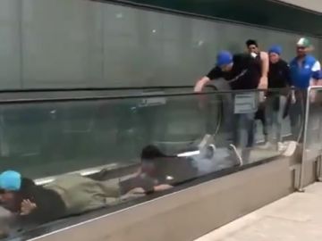 Aficionados del Atalanta "nadando" sobre la cinta mecánica de un aeropuerto Aficionados del Atalanta "nadando" sobre la cinta mecánica de un aeropuerto
