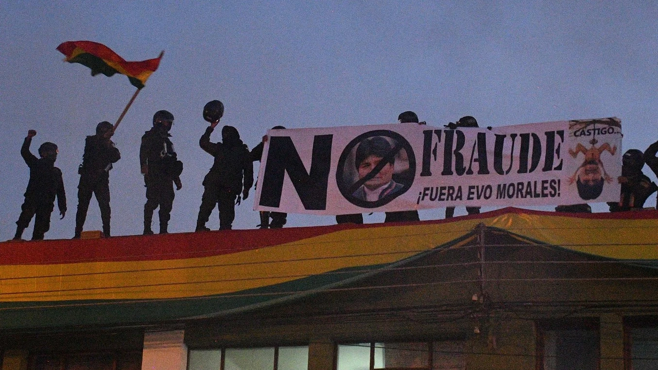 Policías bolivianos despliegan una pancarta en el techo de una unidad policial en Cochabamba