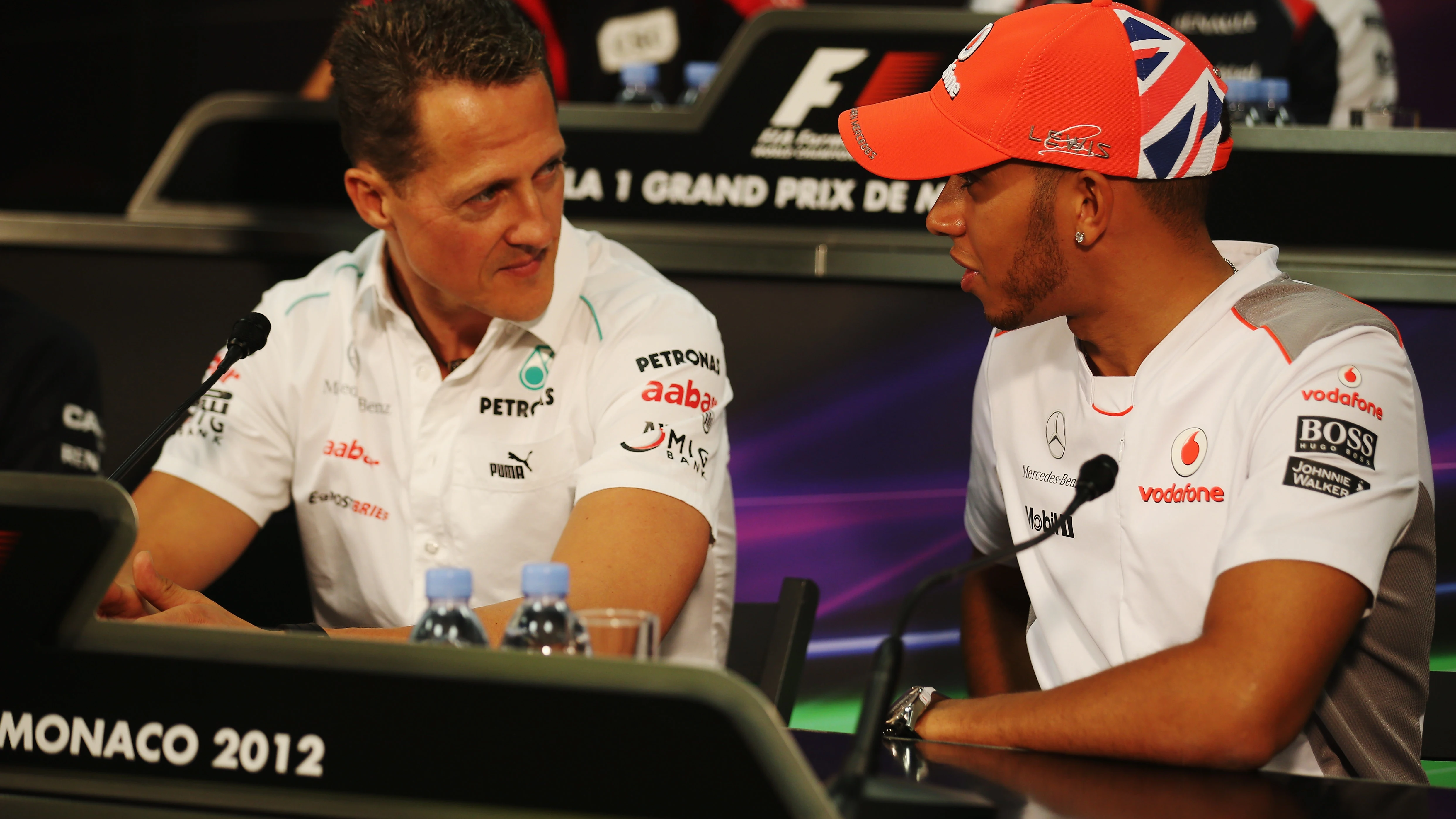 Michael Schumacher y Lewis Hamilton dialogan en una rueda de prensa