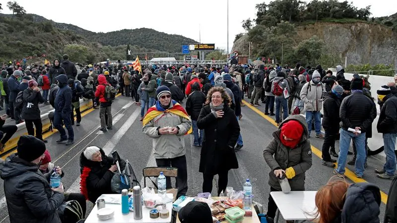 Manifestantes se avituallan durante el bloqueo de la autopista que enlaza España y Francia