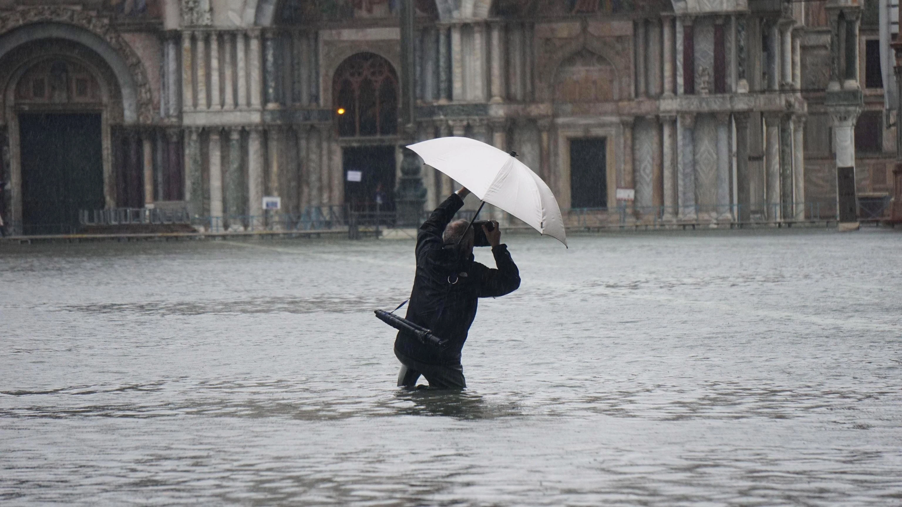 Un hombre sacando una foto durante la inundación