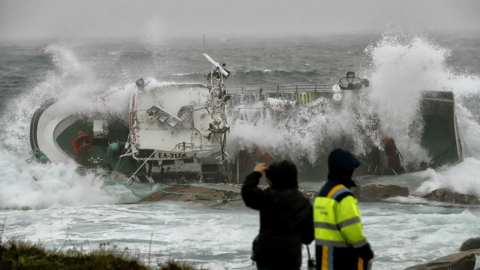 Las olas zarandean un barco en Porto do Son, A Coruña