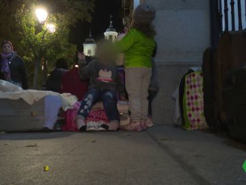 Familias esperando para entrar en un albergue Familias esperando para entrar en un albergue