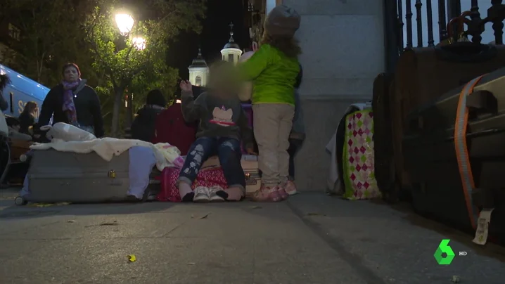 Familias esperando para entrar en un albergue