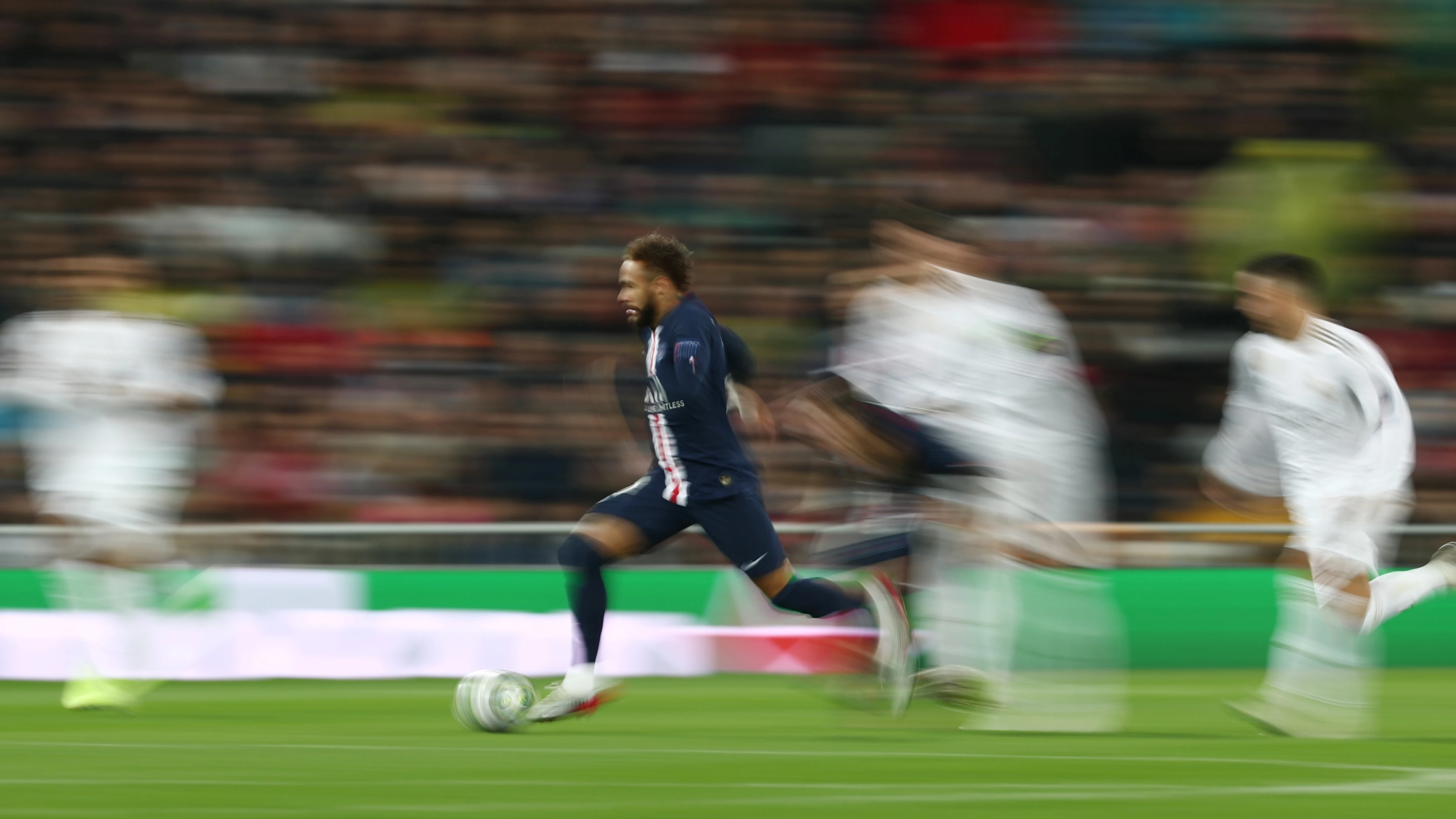 Neymar corre en el Bernabéu ante unos difuminados jugadores del Real Madrid