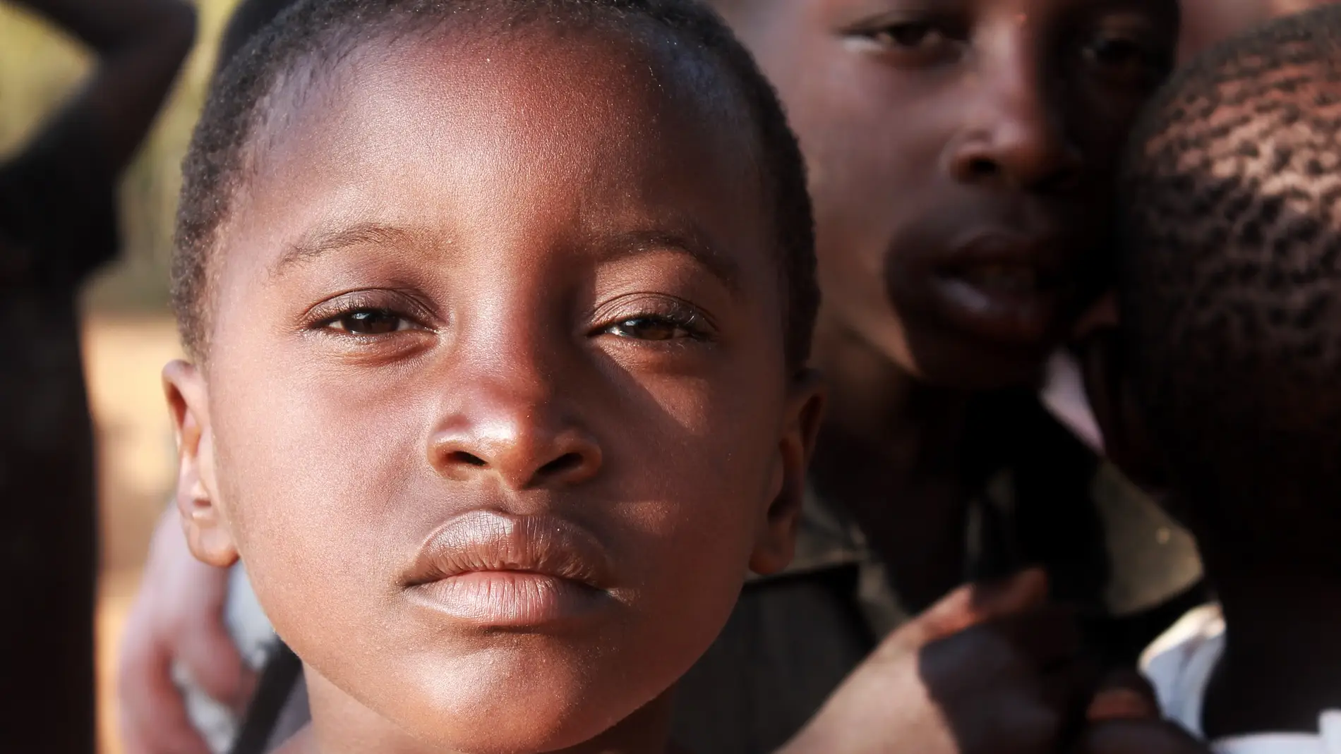 niña africana con familiares al fondo