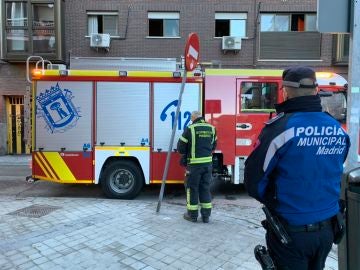 Un bombero y un policía tras el incendio declarado en Vallecas Un bombero y un policía tras el incendio declarado en Vallecas