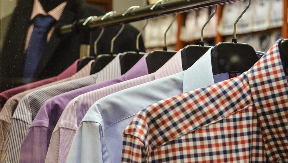 Camisas colgadas en perchas en una tienda de ropa