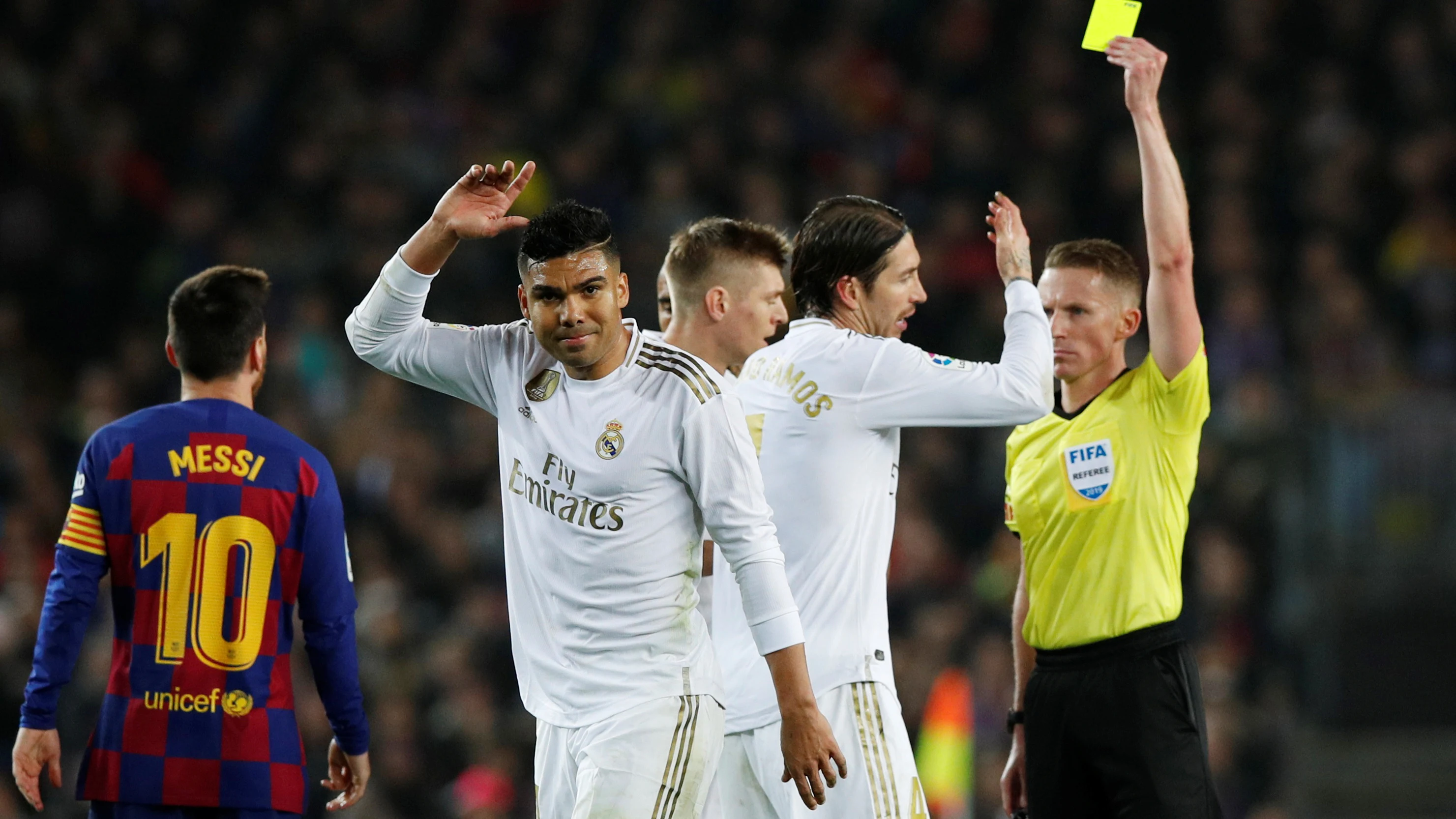 Los jugadores del Real Madrid protestan una amonestación de Hernández Hernández en el Clásico