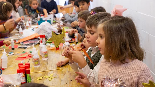 Niños y niñas haciendo adornos de Navidad Navidad