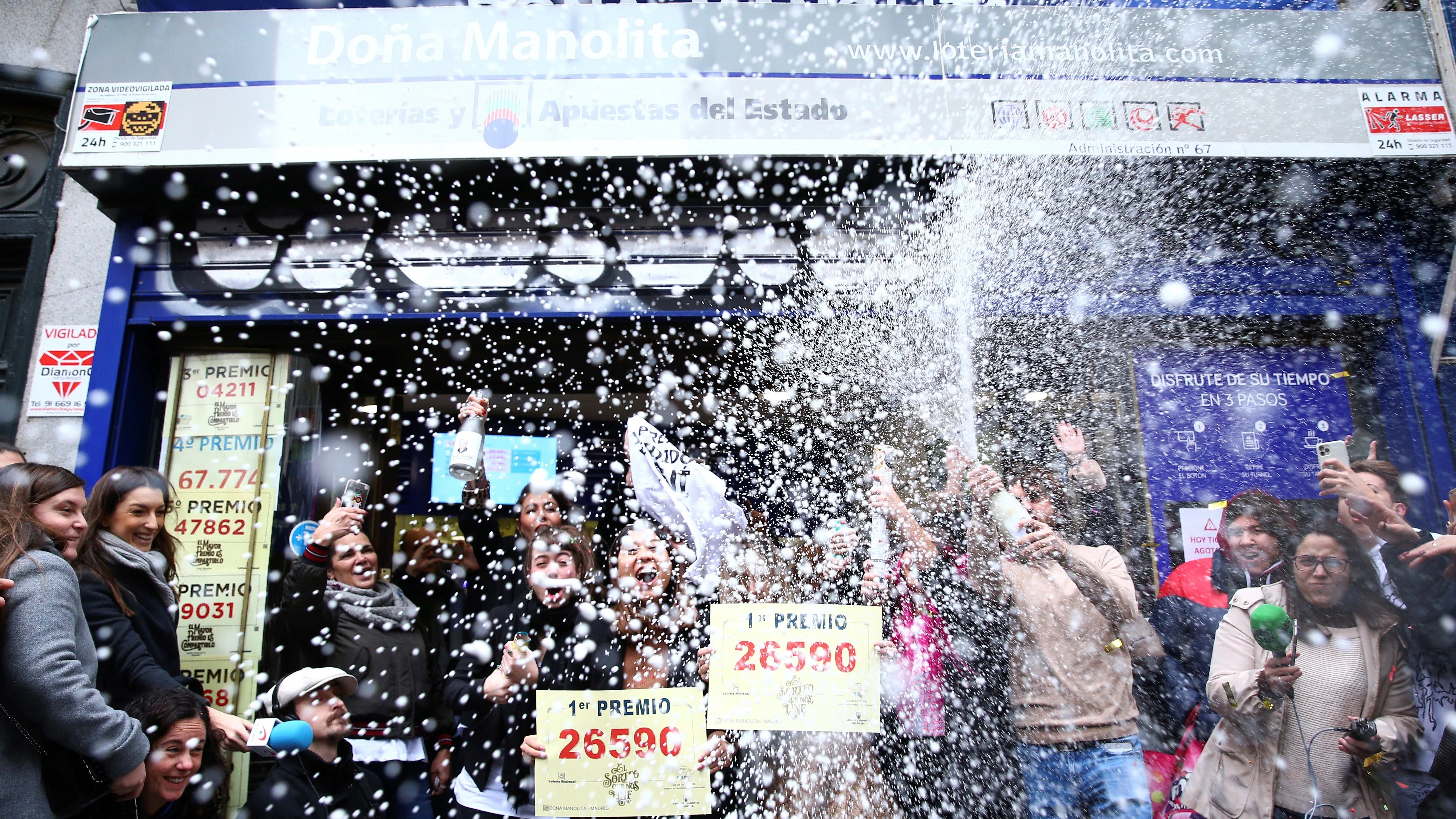 Un grupo de personas celebran en la administración madrileña de Doña Manolita