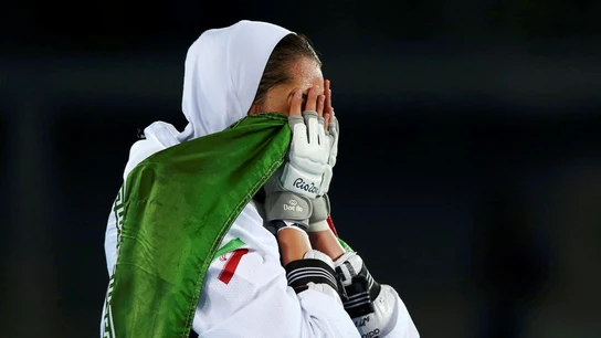 Kimia Alizadeh, emocionada, sostiene la bandera de Irán Kimia Alizadeh, emocionada, sostiene la bandera de Irán