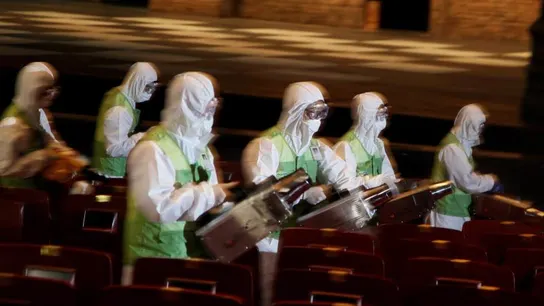 Miembros de una brigada de salud fumigan un teatro en Seúl Miembros de una brigada de salud fumigan un teatro en Seúl