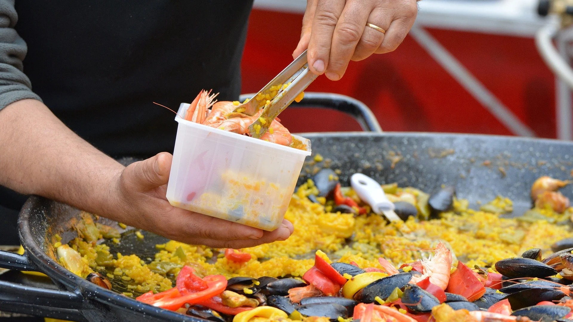 Imagen de una persona cocinando una paella