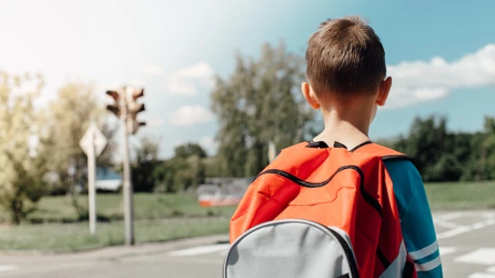 Imagen de un niño con una mochila en la calle Niño con mochila