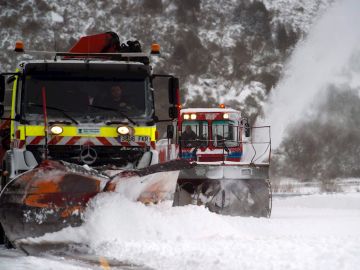 Dos máquinas quitanieves limpian un aparcamiento de nieve en la estación de esquí de Alto Campoo Dos máquinas quitanieves limpian un aparcamiento de nieve en la estación de esquí de Alto Campoo