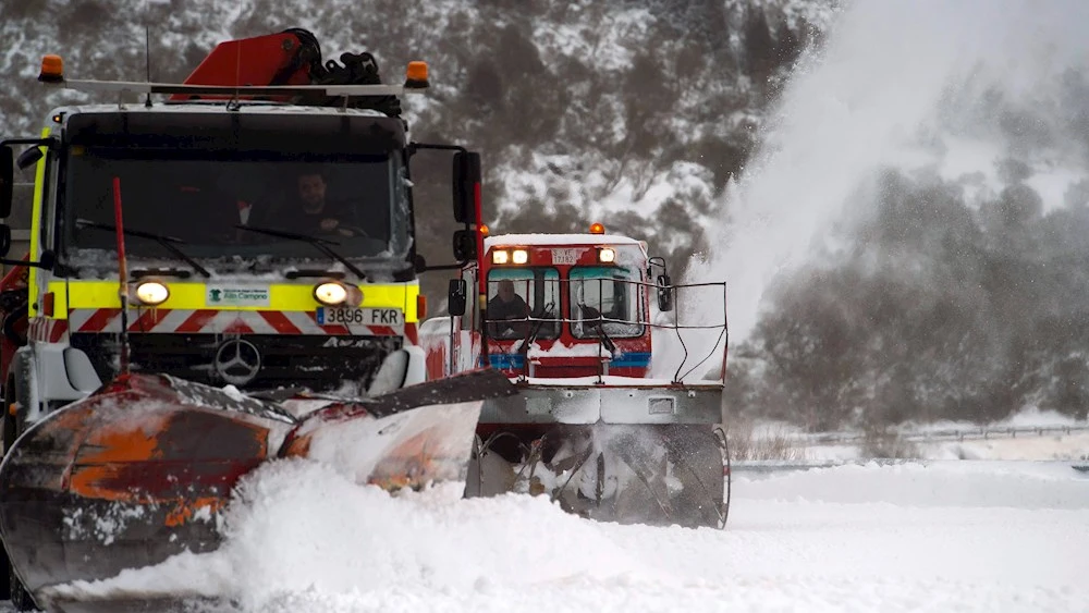 Dos máquinas quitanieves limpian un aparcamiento de nieve en la estación de esquí de Alto Campoo