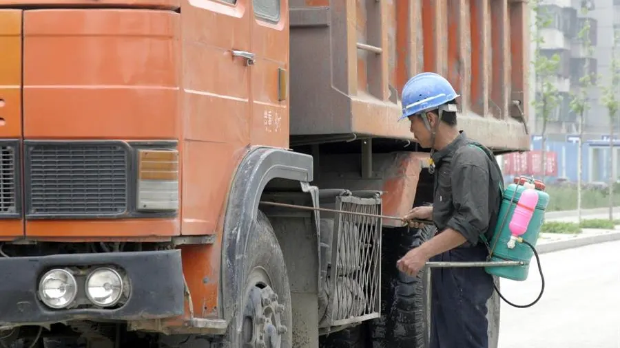 Imagen de un trabajador desinfectando los bajos de un camino en Pekín, China. 