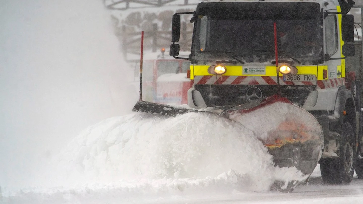 Una quitanieves limpia un aparcamiento de nieve en la estación de esquí de Alto Campoo Una quitanieves limpia un aparcamiento de nieve en la estación de esquí de Alto Campoo