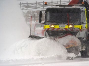 Una quitanieves limpia un aparcamiento de nieve en la estación de esquí de Alto Campoo Una quitanieves limpia un aparcamiento de nieve en la estación de esquí de Alto Campoo