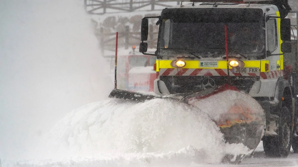 Una quitanieves limpia un aparcamiento de nieve en la estación de esquí de Alto Campoo