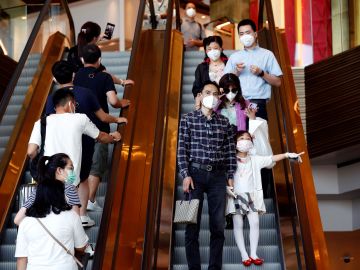 Tailandeses se protegen con mascarillas en un centro comercial en Bankok por el coronavirus Tailandeses se protegen con mascarillas en un centro comercial en Bankok por el coronavirus
