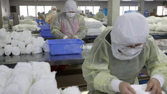 Varias personas trabajan en una fábrica de mascarillas Varias personas trabajan en una fábrica de mascarillas