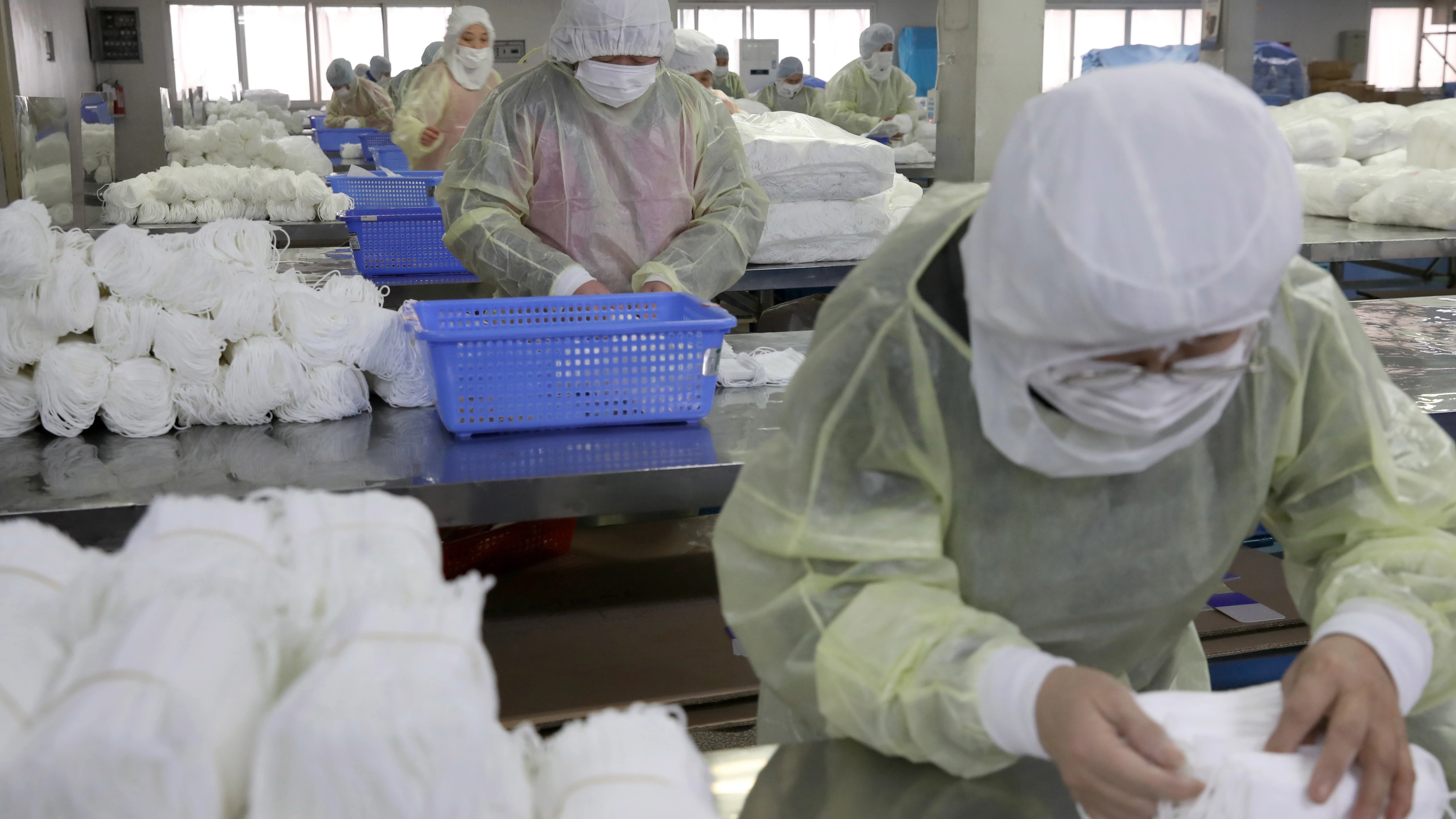 Varias personas trabajan en una fábrica de mascarillas