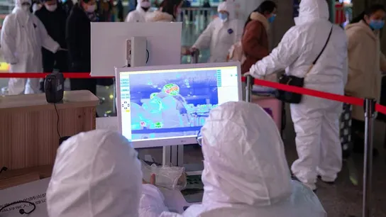 Personal revisan la temperatura de los pasajeros en un aeropuerto Personal revisan la temperatura de los pasajeros en un aeropuerto