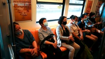 Pasajeros viajando en un tren de Bangkok, en Tailandia