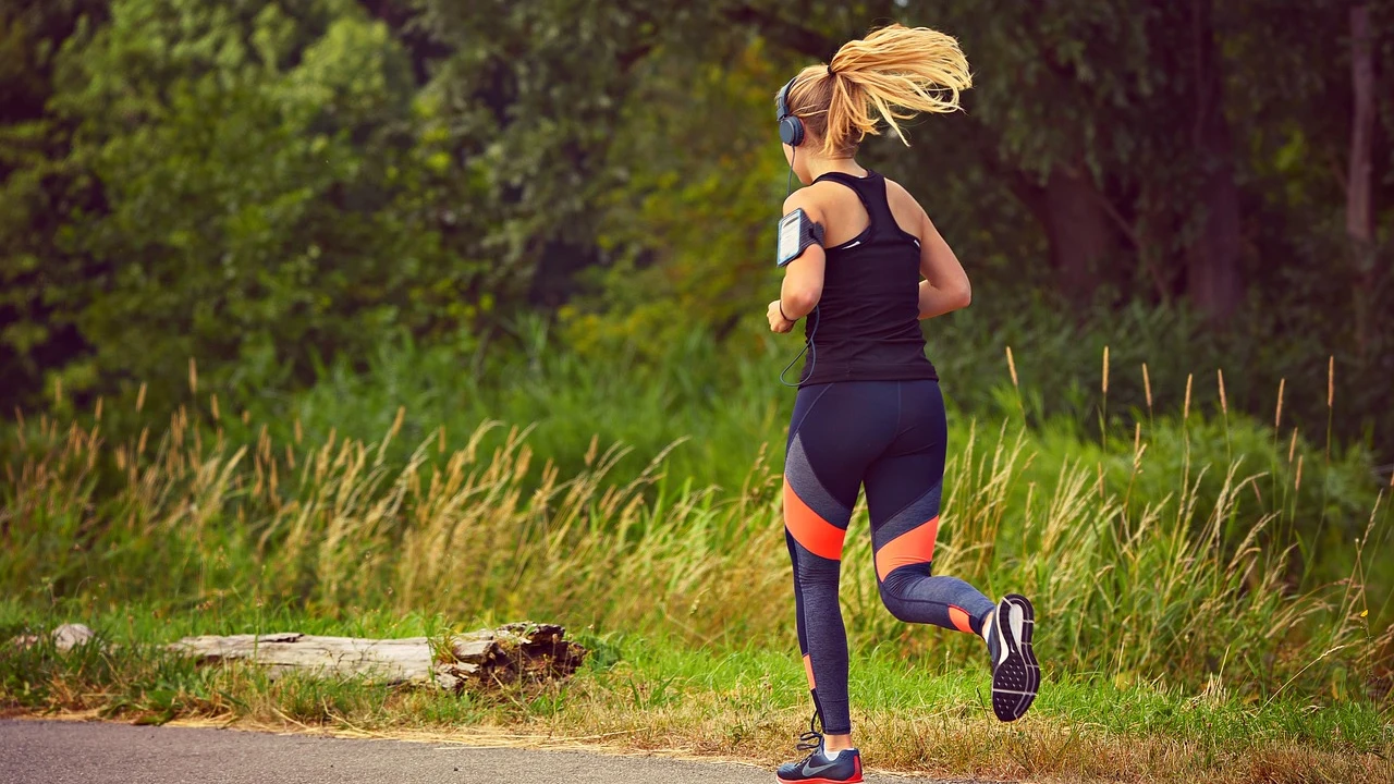 Mujer practicando running mientras escucha música