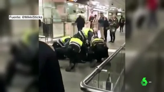 Cuatro vigilantes de Renfe reducen y esposan a un hombre negro tras colarse en la estación Plaza de Catalunya Cuatro vigilantes de Renfe reducen y esposan a un hombre negro tras colarse en la estación Plaza de Catalunya