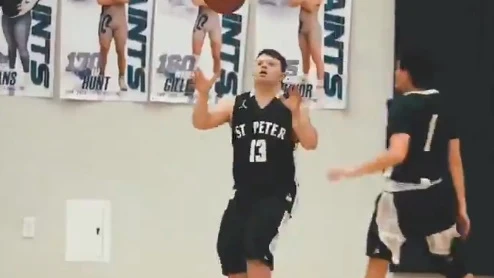 Un niño con síndrome de down jugando al baloncesto.