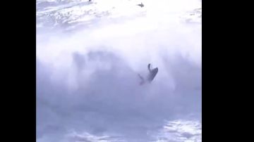 El surfista Alex Botelho remolcado por una moto de agua no logra escapar de las olas