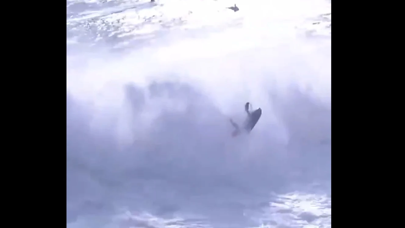 El surfista Alex Botelho remolcado por una moto de agua no logra escapar de las olas