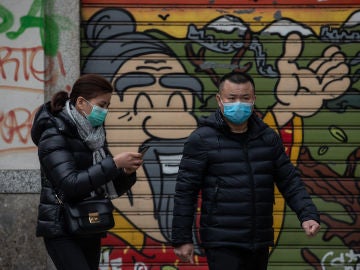 Dos personas con mascarillas por miedo al coronavirus. Dos personas con mascarillas por miedo al coronavirus.
