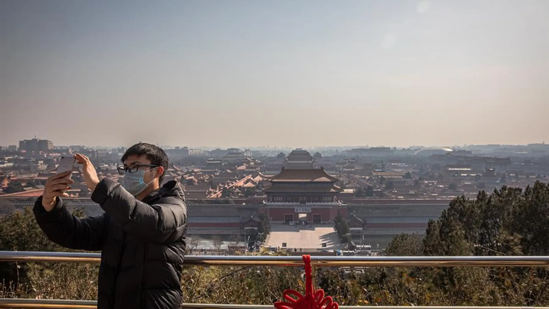 Un hombre se fotografía ante una vacía Ciudad Prohibida de Pekín
