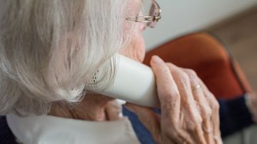 Una anciana hablando por teléfono