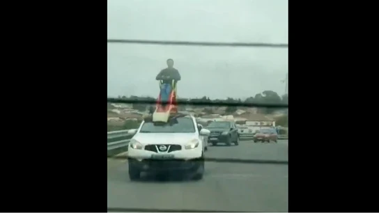 Un hombre subido a un tobogán en el techo de un coche en Chiclana Un hombre subido a un tobogán en el techo de un coche Chiclana
