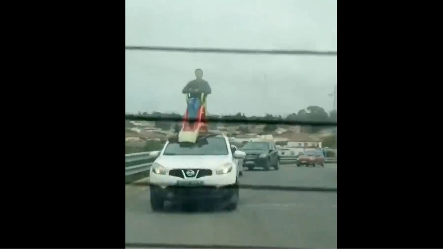 Un hombre subido a un tobogán en el techo de un coche en Chiclana Un hombre subido a un tobogán en el techo de un coche Chiclana