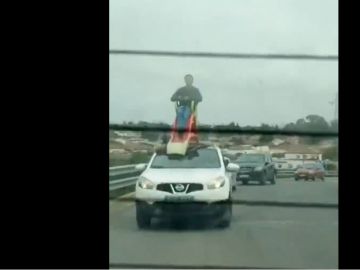 Un hombre subido a un tobogán en el techo de un coche en Chiclana Un hombre subido a un tobogán en el techo de un coche en Chiclana