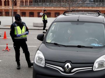 Un policía revisa la documentación de un vehículo en un control de seguridad Un policía revisa la documentación de un vehículo en un control de seguridad