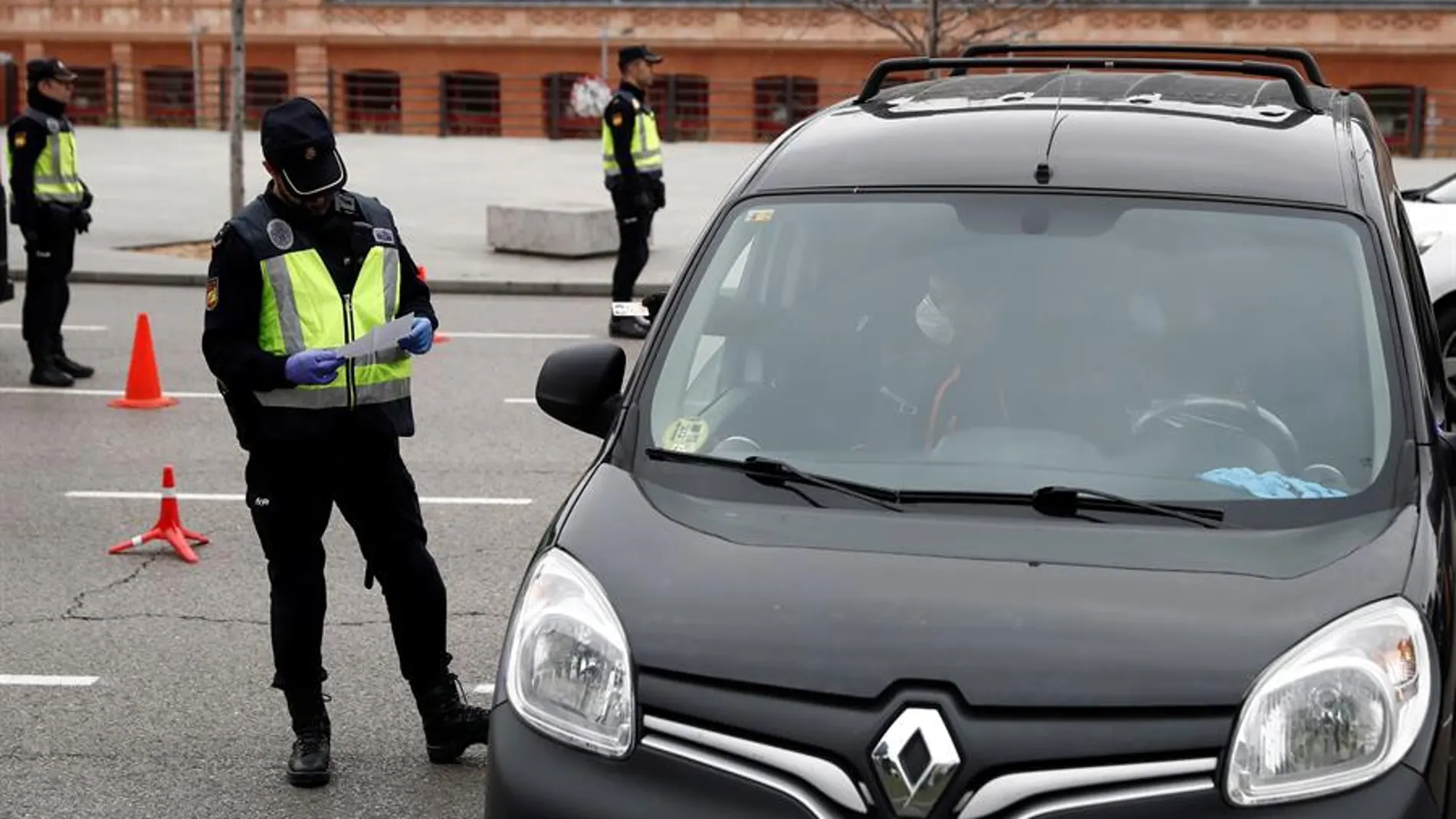 Un policía revisa la documentación de un vehículo en un control de seguridad