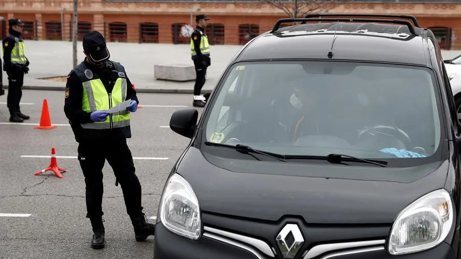 Un policía revisa la documentación de un vehículo en un control de seguridad