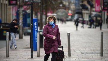 Una ciudadana pasea con una mascarilla puesta