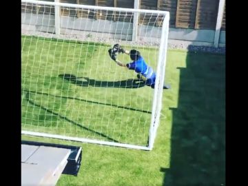 Un joven portero entrenando solo en casa Un joven portero entrenando solo en casa