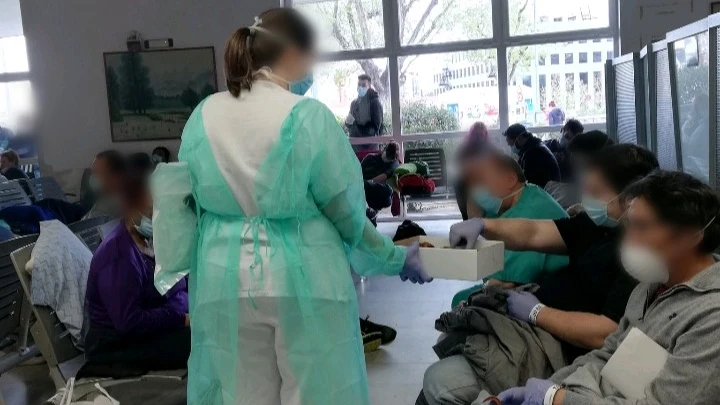 Personal sanitario reparte sándwiches entre los pacientes.
