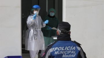 Un médico biólogo de Madrid Salud examina a un policía municipal