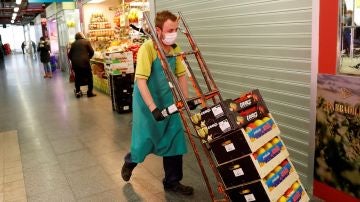 Imagen de un hombre transportando alimentos en un mercado